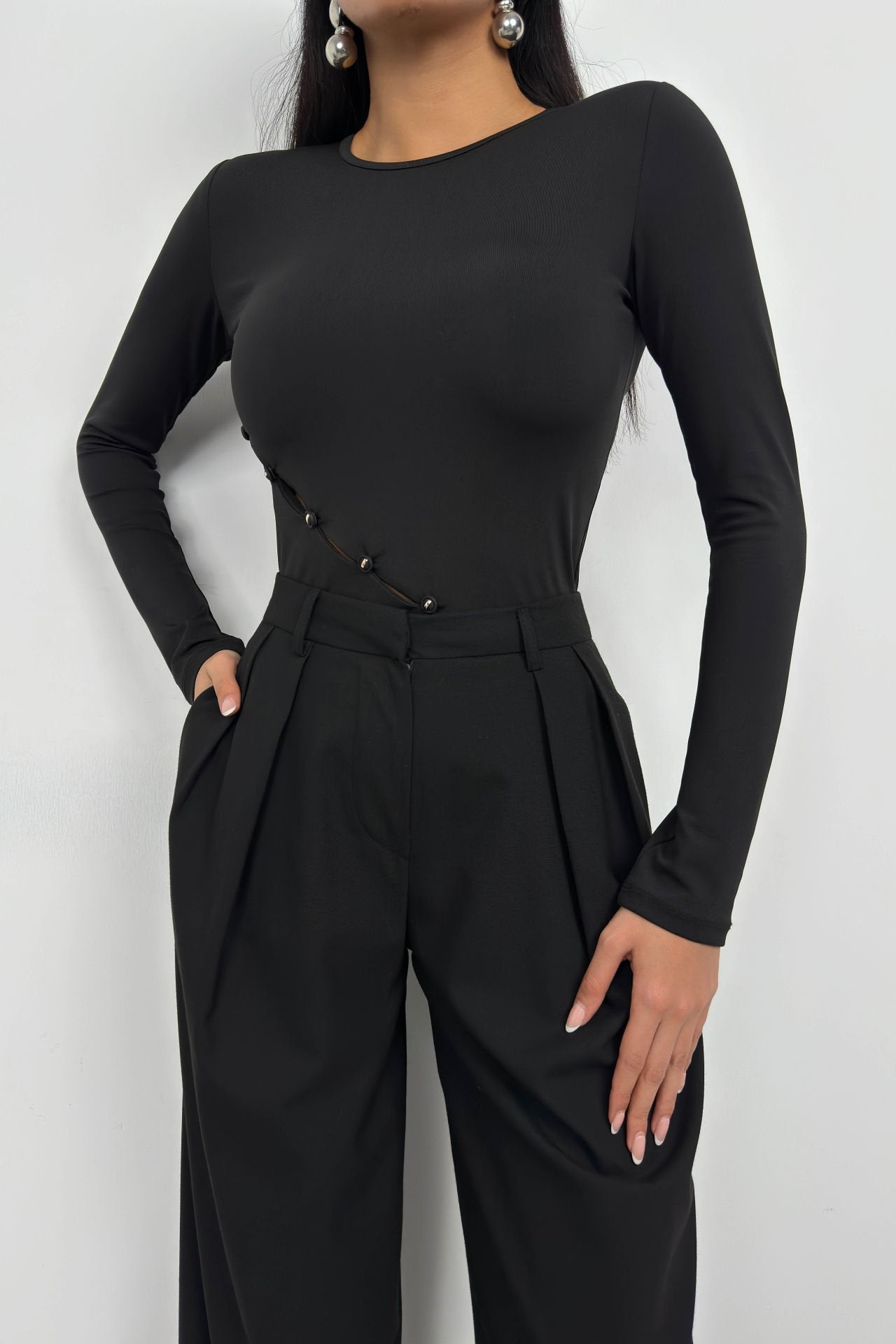 Schwarze Bluse mit langen Ärmeln und asymmetrischem Knopfdetail